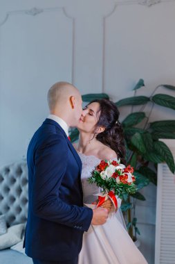 Mutlu gelin ve damat bir odada kucaklaşır..