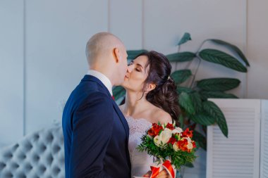Mutlu gelin ve damat bir odada kucaklaşır..