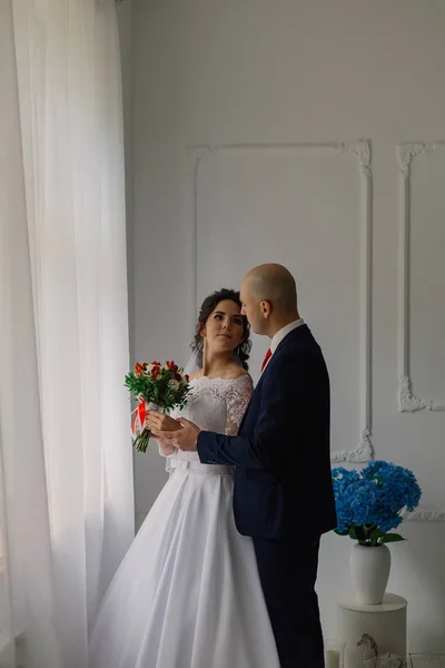 Mariée heureuse et marié dans une chambre s'embrassent . — Photo