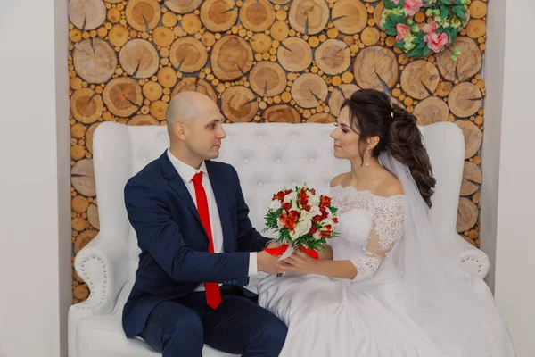 Beautiful and happy bride and groom are sitting on the couch. — 스톡 사진