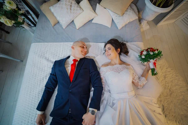 Noiva feliz e noivo jazem na cama . — Fotografia de Stock
