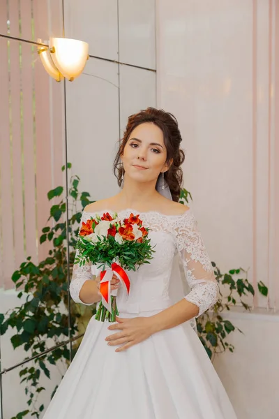 Hermosa novia feliz en una habitación con un ramo de bodas . —  Fotos de Stock