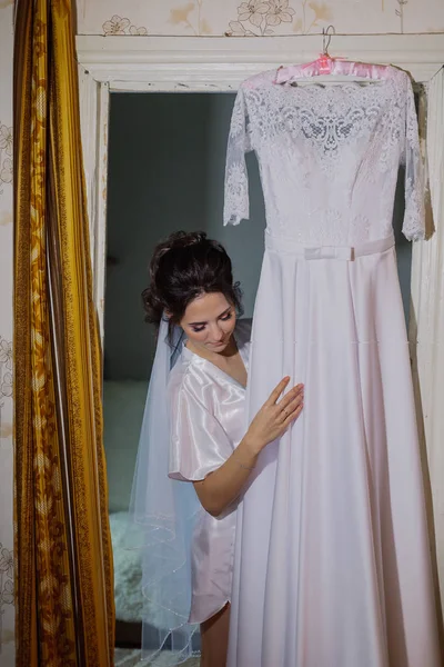 Hermosa novia feliz toca su vestido de novia . —  Fotos de Stock