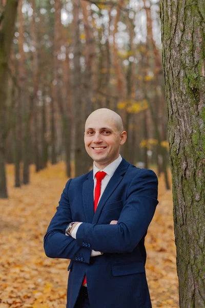 Guapo hombre con estilo en una chaqueta en el otoño en el bosque . — Foto de Stock