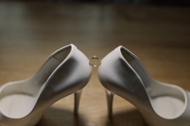 Shoes of the bride with wedding rings. Happy wedding day.