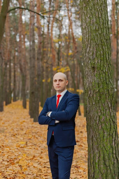 Guapo hombre con estilo en una chaqueta en el otoño en el bosque . — Foto de Stock