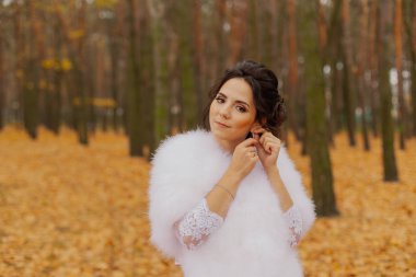 Happy beautiful bride in the autumn in the forest.