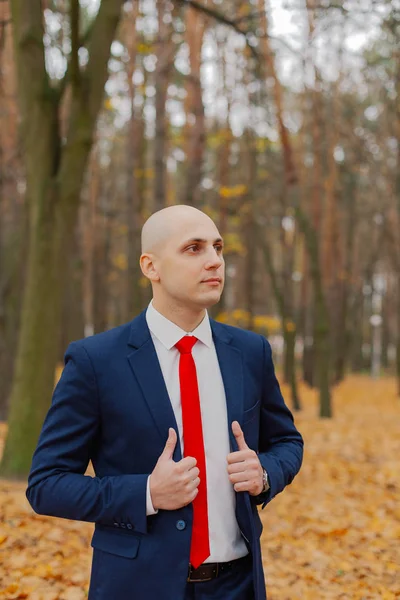 Guapo hombre con estilo en una chaqueta en el otoño en el bosque . — Foto de Stock