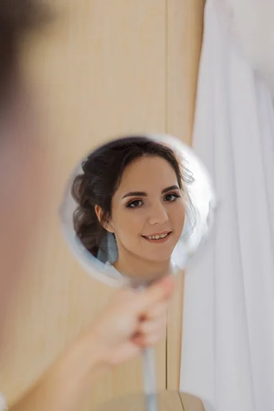 Schöne Frau, die sich selbst im Spiegel betrachtet. — Stockfoto