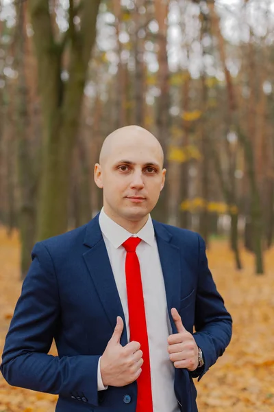 Guapo hombre con estilo en una chaqueta en el otoño en el bosque . — Foto de Stock