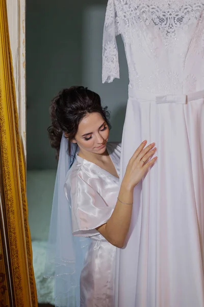 Hermosa novia feliz toca su vestido de novia . — Foto de Stock