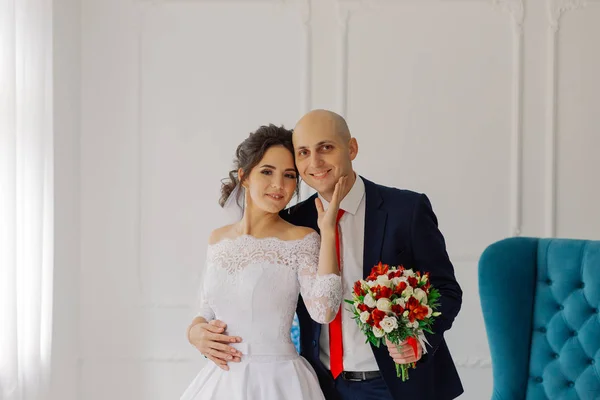 Novia y novio felices en una habitación abrazarse mutuamente . — Foto de Stock