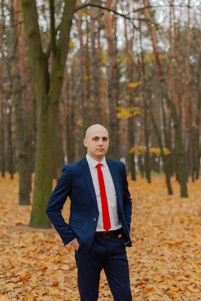 Guapo hombre con estilo en una chaqueta en el otoño en el bosque . — Foto de Stock