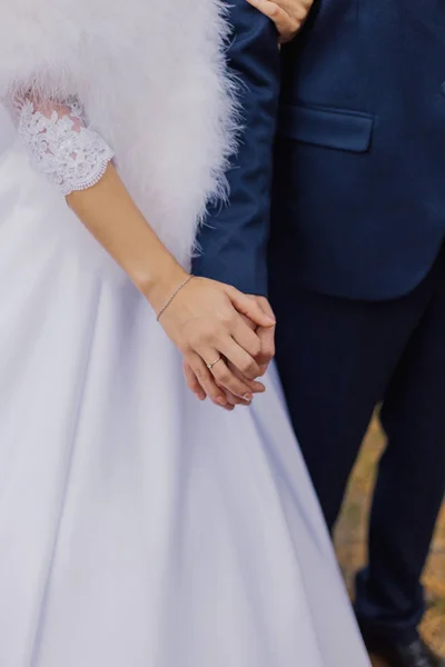 Glückliche Braut und Bräutigam stehen Händchen haltend im Herbstwald. — Stockfoto