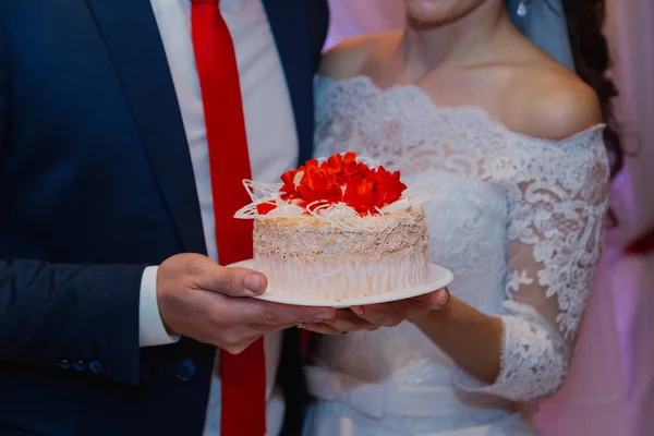 幸せな新婚夫婦は彼らの手に結婚式のケーキを保持します. — ストック写真