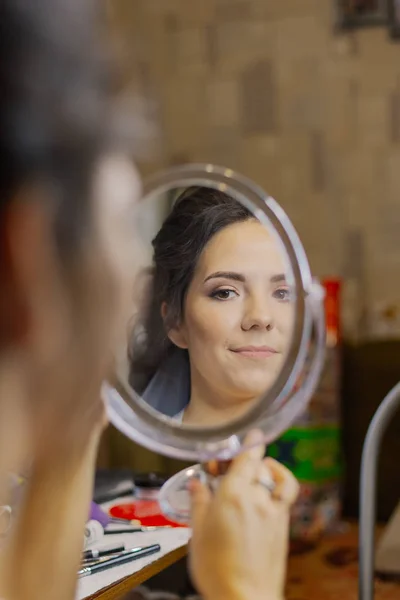 Beautiful woman looking at herself in the mirror. — Stock Photo, Image