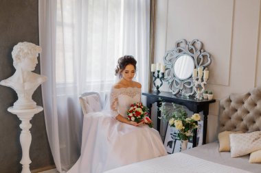 Düğün buketi olan bir odada güzel mutlu bir gelin..