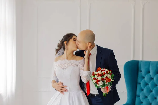 Glückliche Braut und Bräutigam in einem Zimmer umarmen einander. — Stockfoto