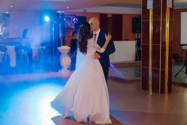 Feliz recém-casados dançam na pista de dança a primeira dança . — Fotografia de Stock