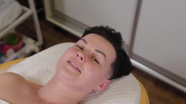 Beautiful woman lies on a couch before a cosmetic procedure. — Stockvideo