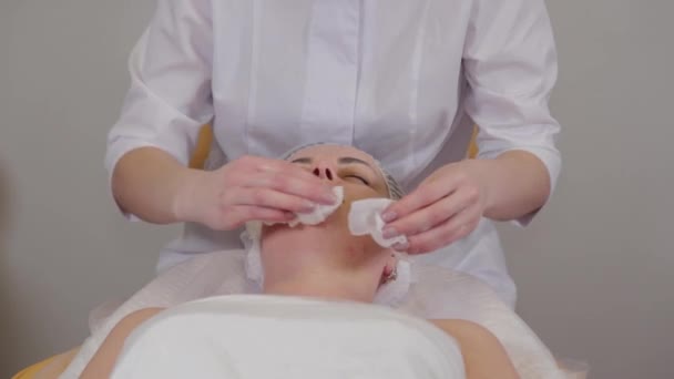 Professional beautician washes face to patient before procedure. — Stockvideo