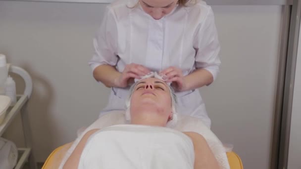 Professional beautician washes face to patient before procedure. — Stock Video