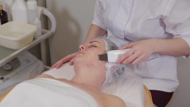 Профессиональный косметолог женщина делает ультразвуковой очистки лица к пациенту. — стоковое видео