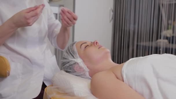 Cosmetologist profissional mulher limpa clientes rosto com almofadas de algodão . — Vídeo de Stock
