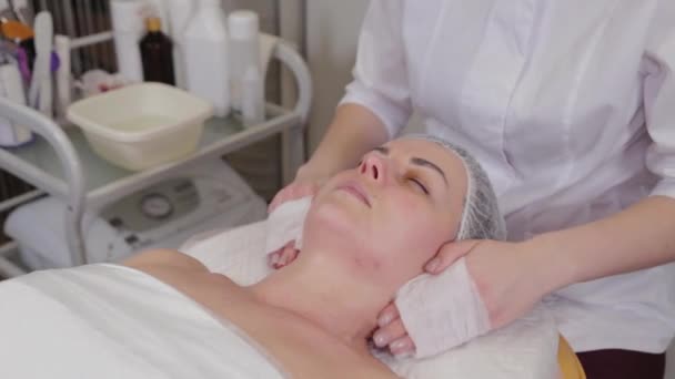 Professional beautician washes face to patient before procedure. — 비디오