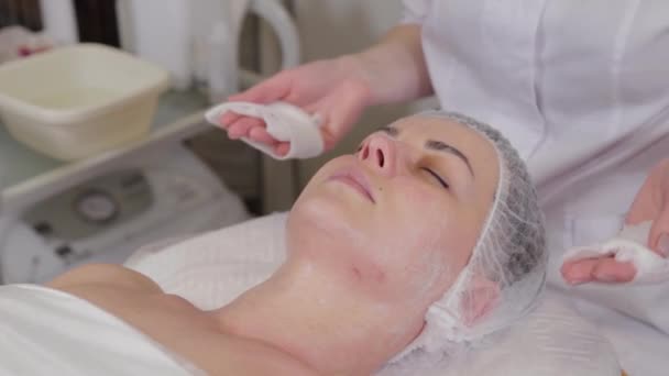 Esteticista profissional lava cara a cara paciente antes do procedimento . — Vídeo de Stock