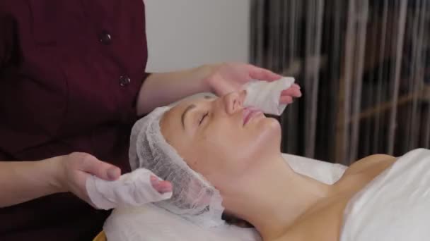 Esteticista profissional lava cara a cara paciente antes do procedimento . — Vídeo de Stock