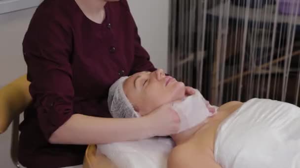 Esthéticienne professionnelle lave le visage au patient avant la procédure . — Video