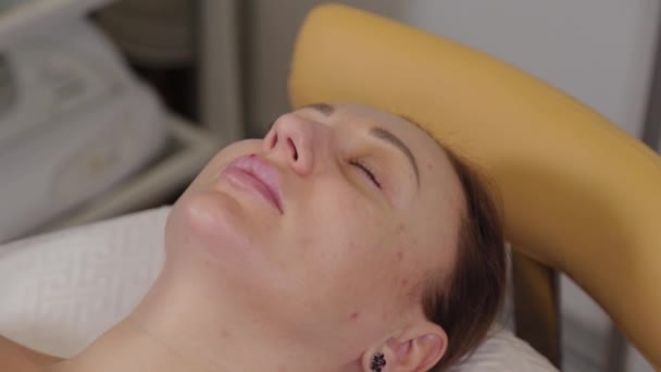 Belle femme se couche sur un canapé avant une procédure cosmétique . — Video