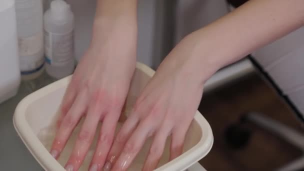 Beautician moistening towel before facial mask procedure at luxury spa salon. — Stock Video