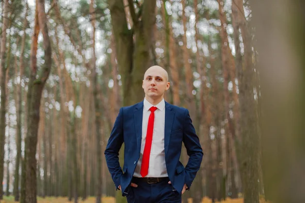 Bonito homem elegante em uma jaqueta no outono na floresta . — Fotografia de Stock