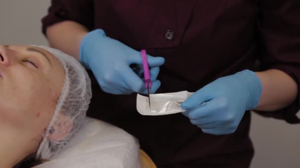 Mujer cosmetóloga profesional saca una boquilla en un dispositivo micronideo . — Vídeos de Stock