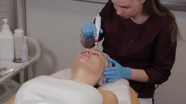 Mujer esteticista profesional realiza micronidling la piel facial . — Vídeos de Stock