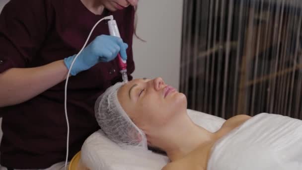 Professional beautician woman performs micronidling facial skin. — Stok video