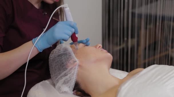 Mujer esteticista profesional realiza micronidling la piel facial . — Vídeos de Stock