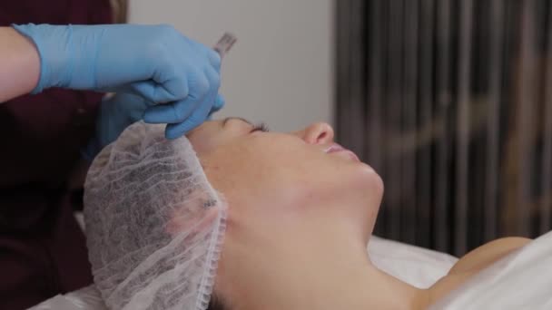 Professional beautician woman performs micronidling facial skin. — Stok video