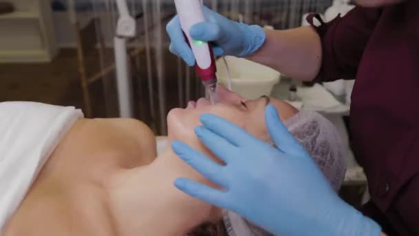 Professional beautician woman performs micronidling facial skin. — Stok video