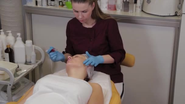 Mujer esteticista profesional realiza micronidling la piel facial . — Vídeos de Stock