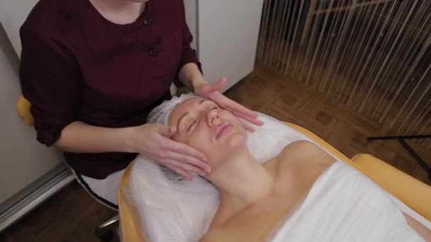 Szakmai kozmetológus nő csinál arcmasszázs az ügyfél a szépségszalon. — Stock videók