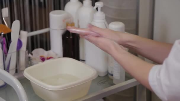 プロの美容師は彼女の手に液体石鹸をこすります. — ストック動画
