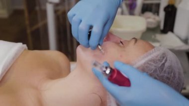 Profesyonel kozmetolog kadın hastalara serum uyguluyor..
