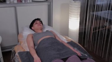 Beautiful woman lies on a couch before a cosmetic procedure.