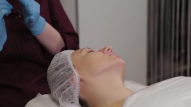 Professional beautician woman performs micronidling facial skin.