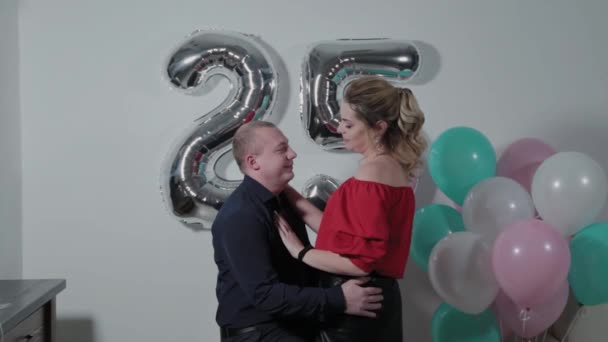 Beautiful man and woman cuddling near birthday balloons. — ストック動画