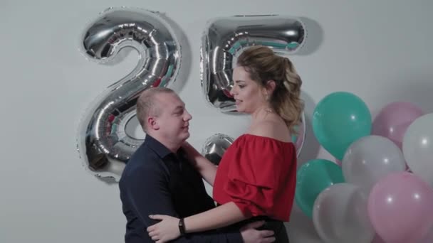 Beautiful man and woman cuddling near birthday balloons. — ストック動画