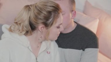 Güzel ve genç bir adam ve bir kadın yatakta sarılıyorlar..